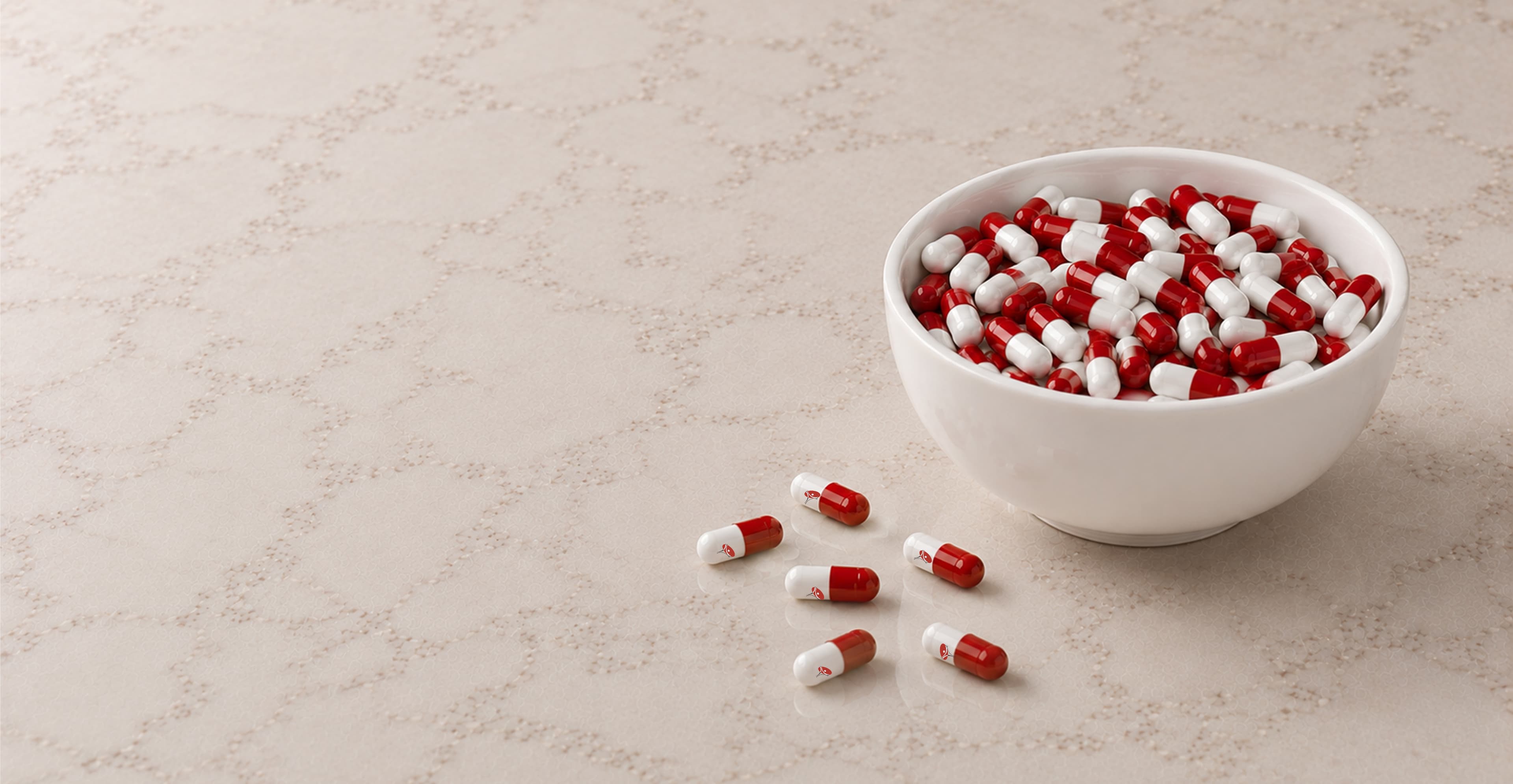 Red and white Saviour capsules filling a ceramic bowl, with loose capsules scattered beside it